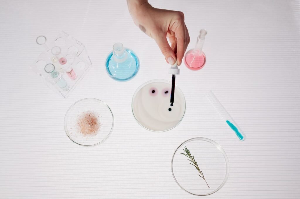 Overhead view of a lab experiment using droppers, petri dishes, and colorful solutions.