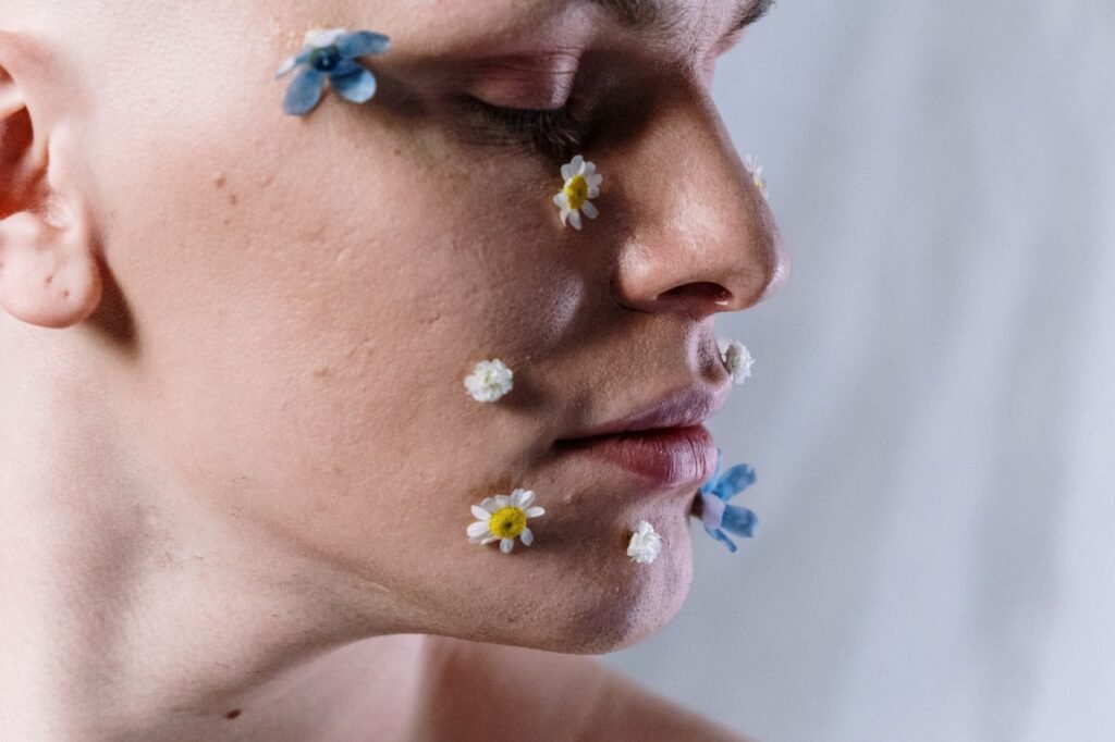 Artistic portrait highlighting floral makeup on a serene face, conveying beauty and creativity.